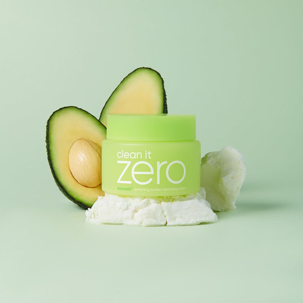 Grüner Behälter neben Avocadoscheiben und weißer Butter auf hellem Hintergrund.