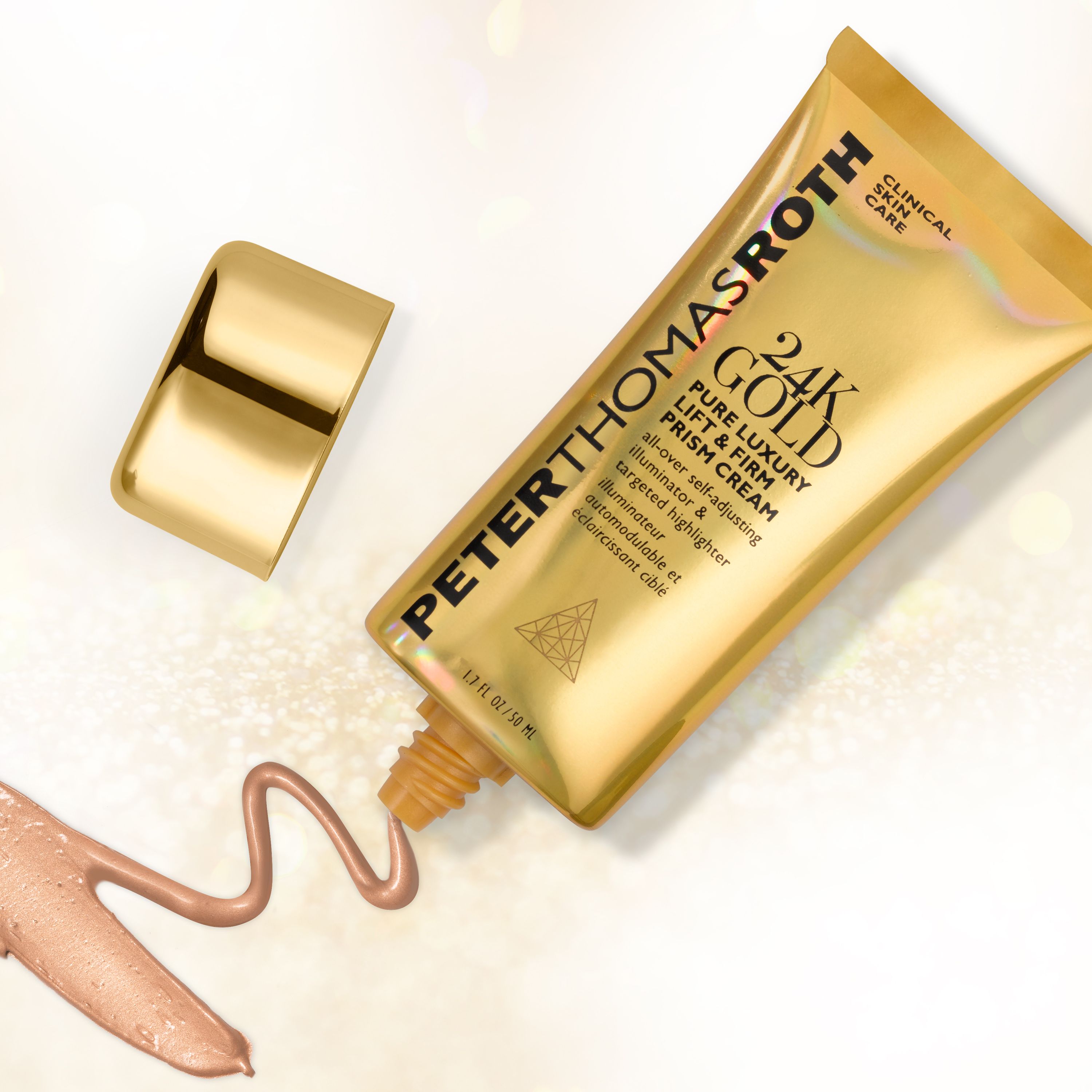 Goldfarbene Tube, Kappe daneben. Produktname und Schriftzug. Peter Thomas Roth 24K Gold Pure Luxury Lift & Firm Prism Cream. Creme-Ausfluss.