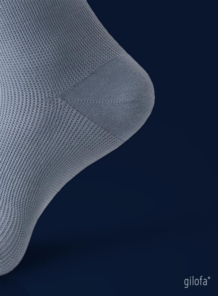 Detailaufnahme des Fußes eines hellgrauen Kompressionsstrumpfes. Rippstrickmuster.
