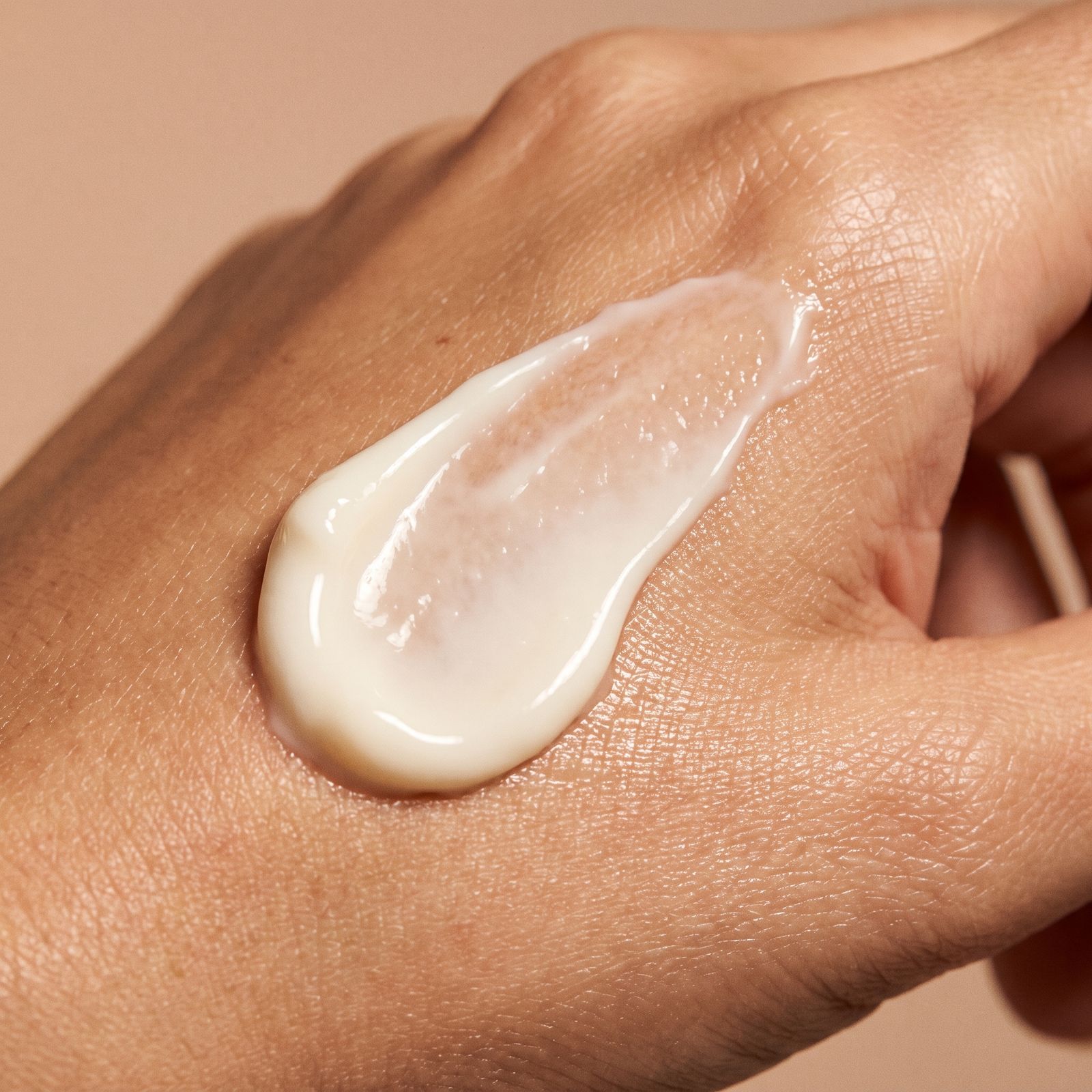 Cremige Handcreme auf einer Hand aufgetragen. Helle, weiße Textur.