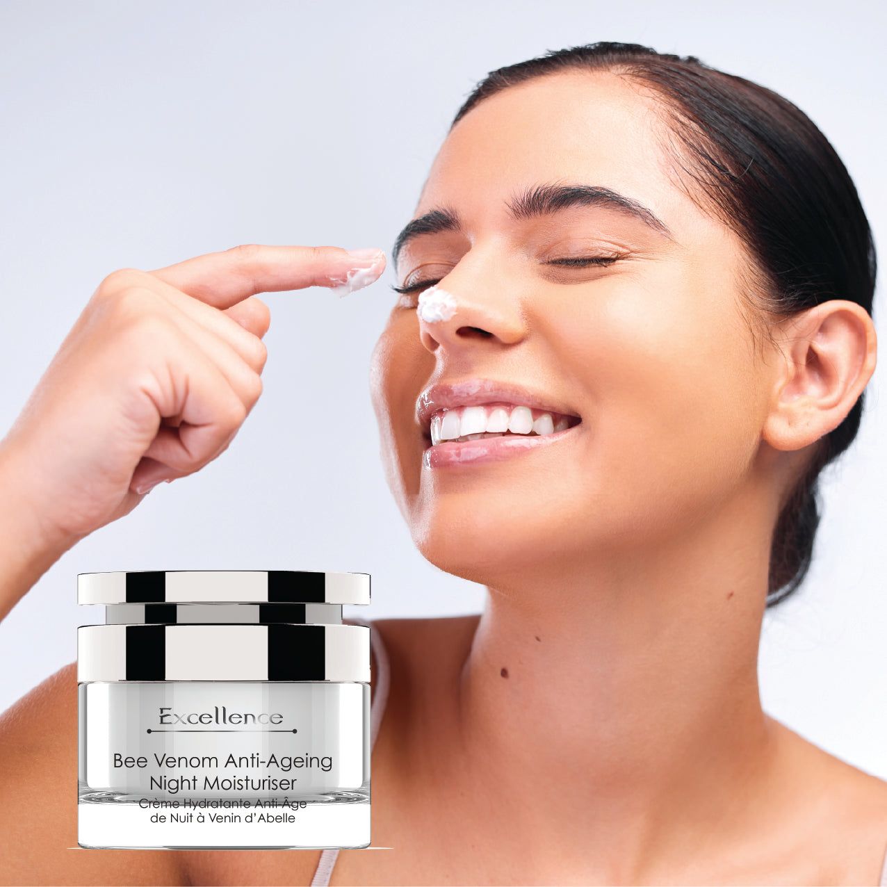 Frau trägt Creme auf. Creme-Tiegel mit Aufschrift: Excellence Bee Venom Anti-Ageing Night Moisturiser.