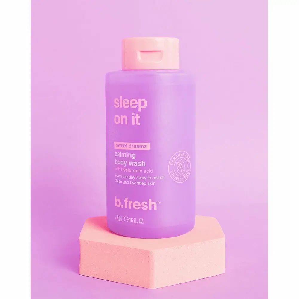 Lila Duschgel-Flasche mit rosa Deckel. Text: "sleep on it", "calming body wash", "b.fresh". Steht auf einem rosa Podest.
