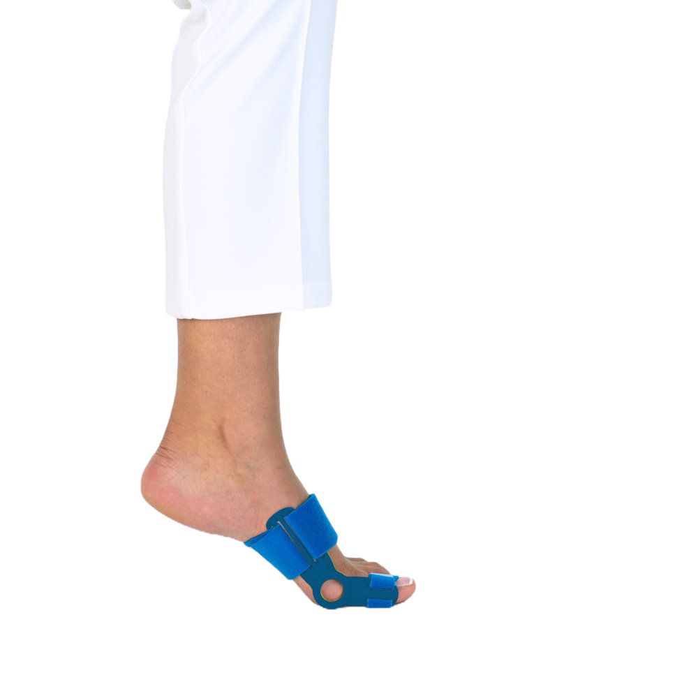 Blaues Hallux-Valgus-Schiene Slim Comfort 2.0 am Fuß. Klettverschluss. Bein in weißer Hose. Weißer Hintergrund.