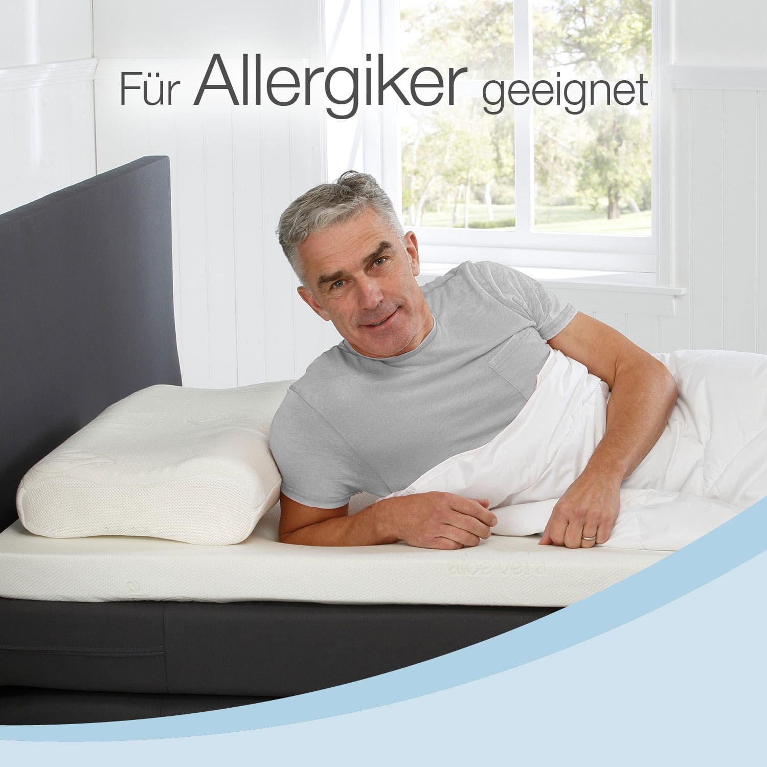 Mann liegt auf Matratzenauflage. Text: Für Allergiker geeignet. Kissen und Decke.