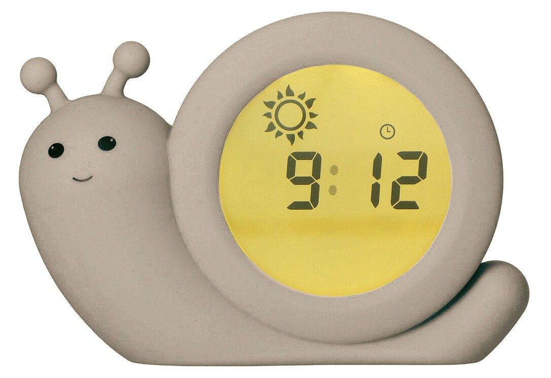 Beigefarbener Schlaftrainer in Schneckenform. Digitalanzeige mit Uhrzeit und Sonnensymbol. Die Uhr zeigt 9:12 an.