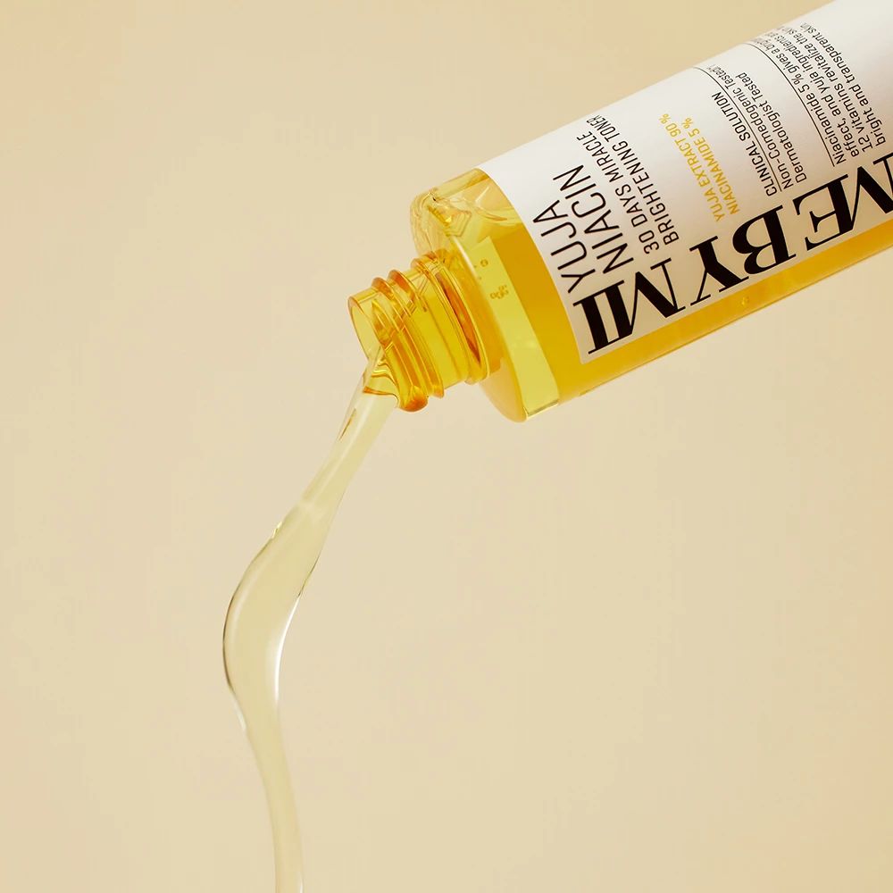Gelbe Flasche mit gelbem Deckel, Flüssigkeit wird ausgegossen. Aufschrift: Yuja Niacin 30 Days Miracle Brightening Toner.