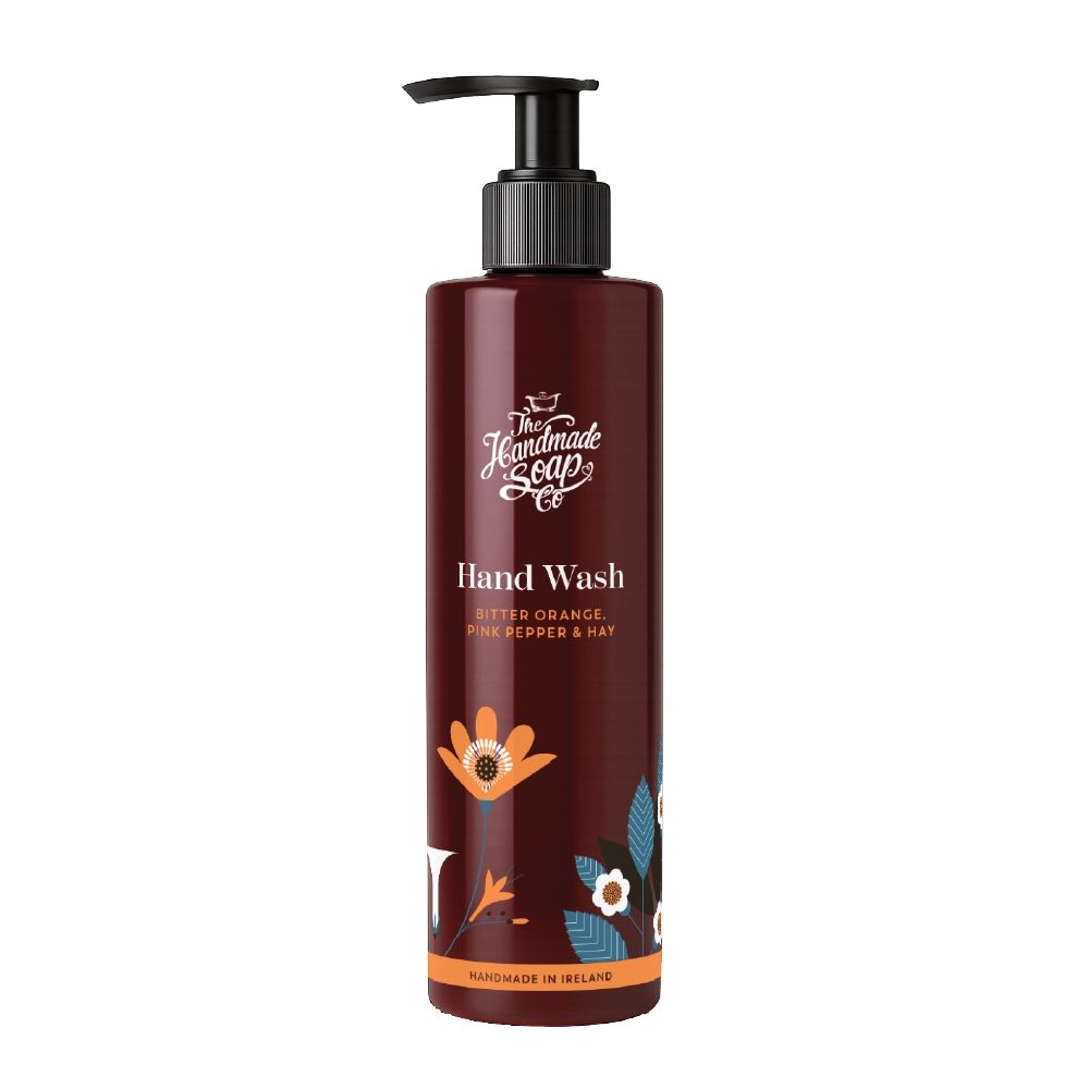 Braune Handseife-Flasche mit schwarzem Pumpkopf. Aufschrift: Hand Wash, Bitter Orange, Pink Pepper & Hat. Mit floralen Elementen.