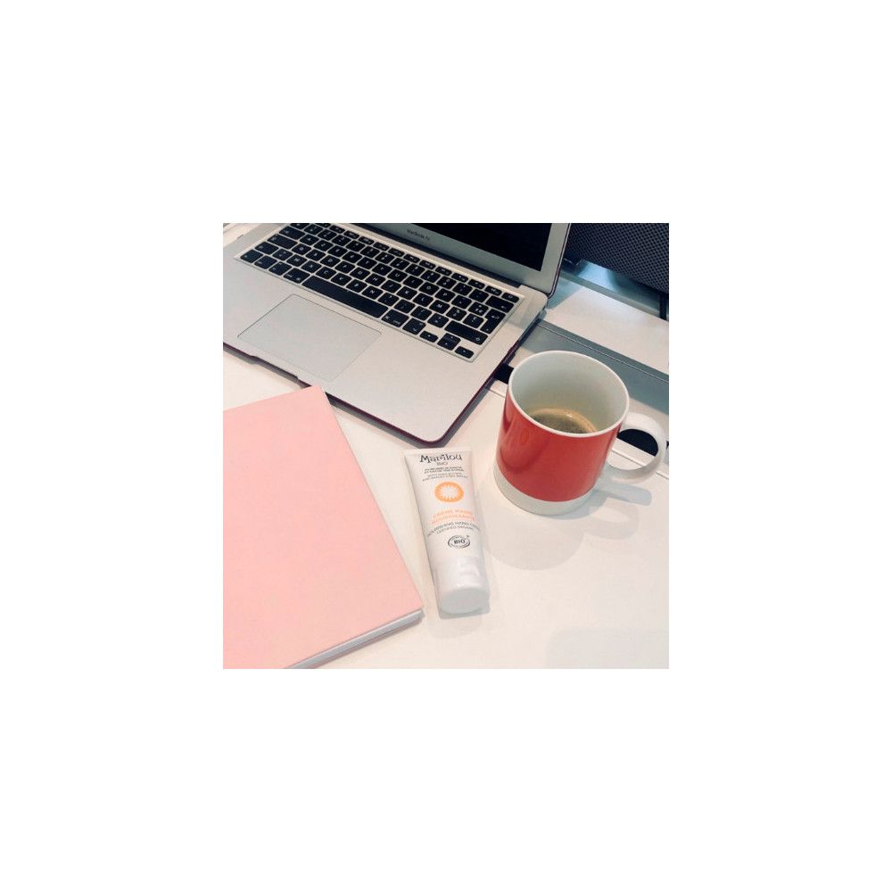Handcreme-Tube, weiß, mit Marilou Bio Logo und Text. Auf einem Schreibtisch mit Laptop und Tasse.