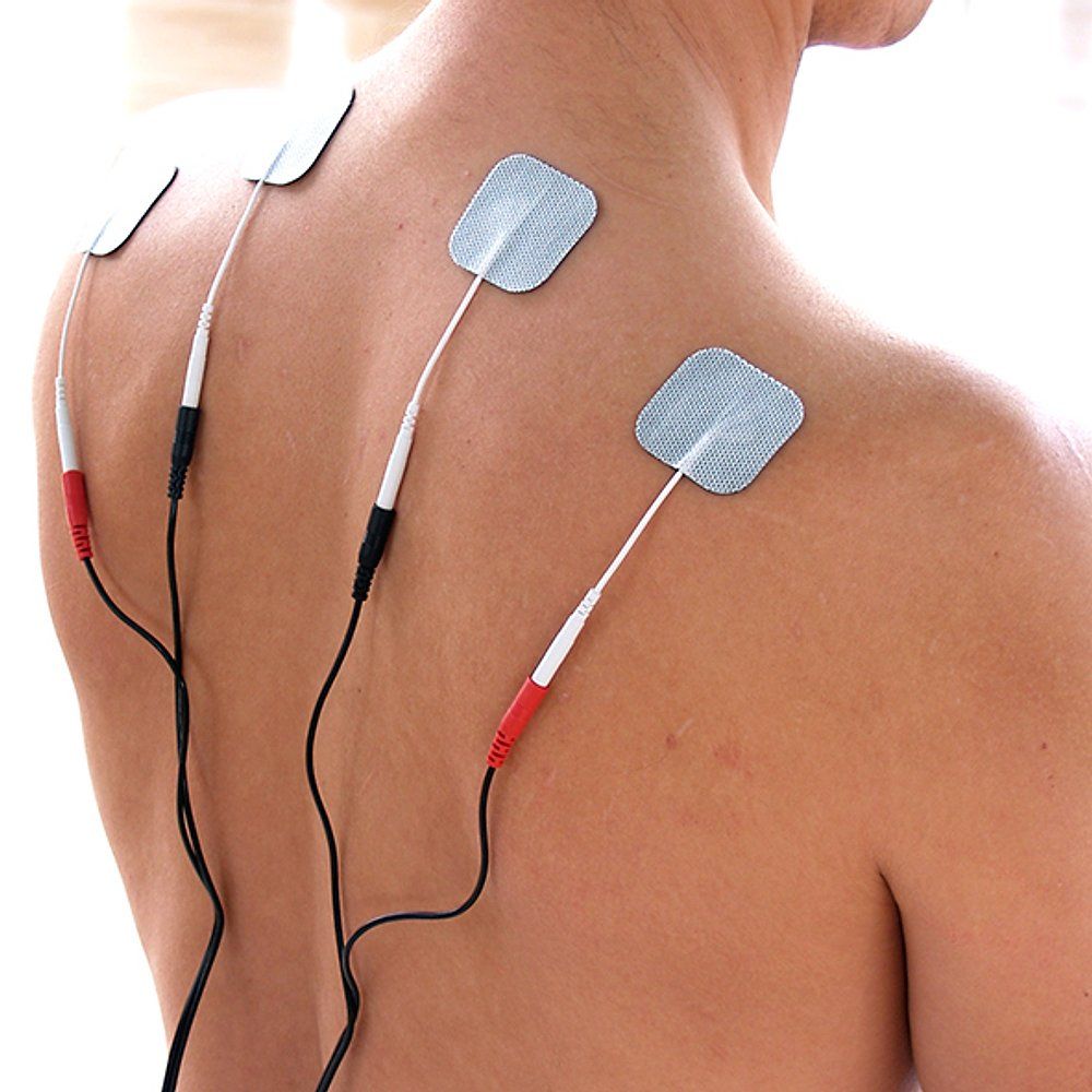 Rücken einer Person mit Elektrodenpads und Kabeln. Pads rechteckig, mit Kabeln verbunden. Keine Geräte sichtbar.