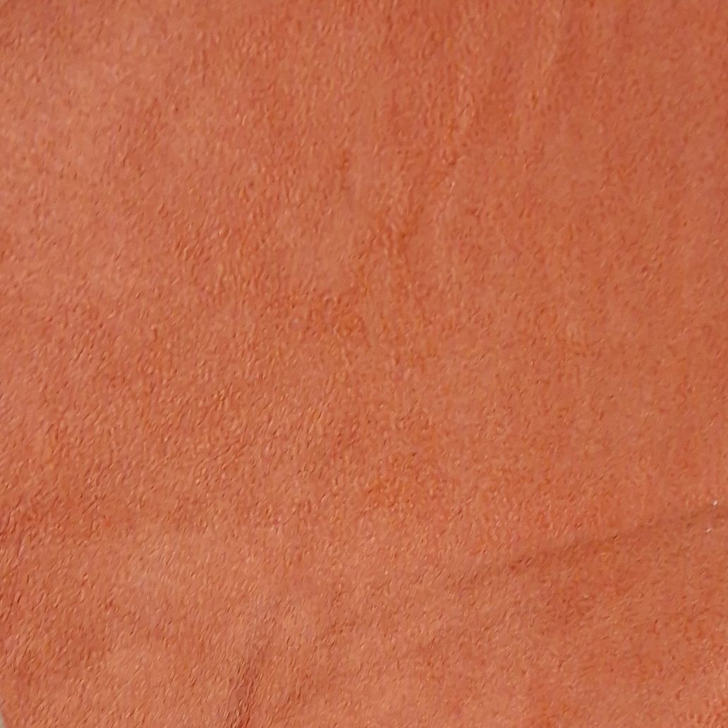 Nahaufnahme eines orangefarbenen Stoffes mit rauer Oberfläche. Texturdetail, keine weiteren Merkmale erkennbar.
