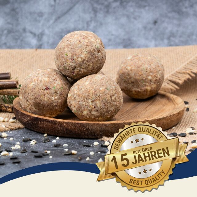 Meisenknödel auf Holzschale. Goldene Plakette: Bewährte Qualität, seit über 15 Jahren, Best Quality. Hintergrund: Samen.