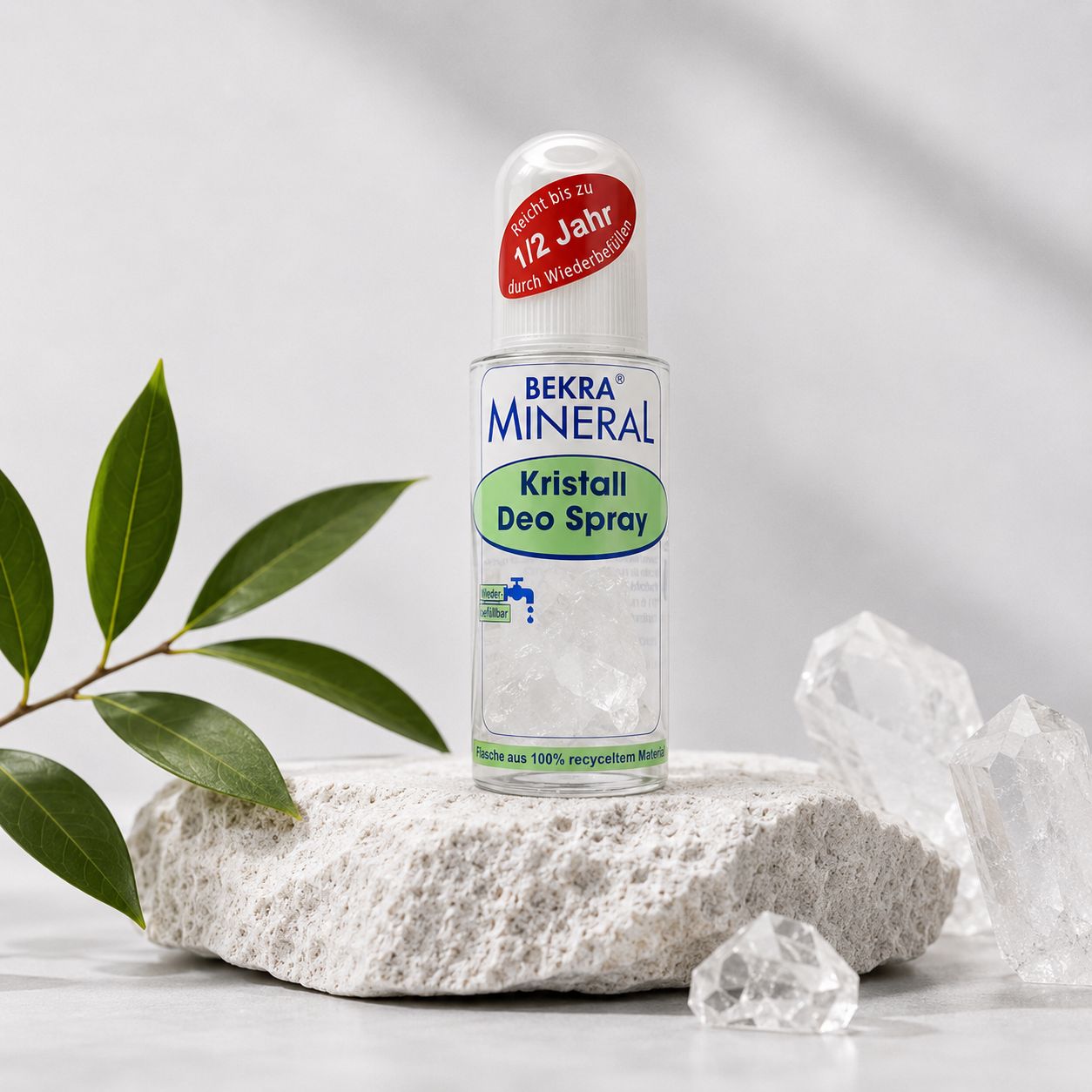 BEKRA Mineral Kristall Deo Spray auf Stein mit grünen Blättern und Kristallen im Hintergrund.