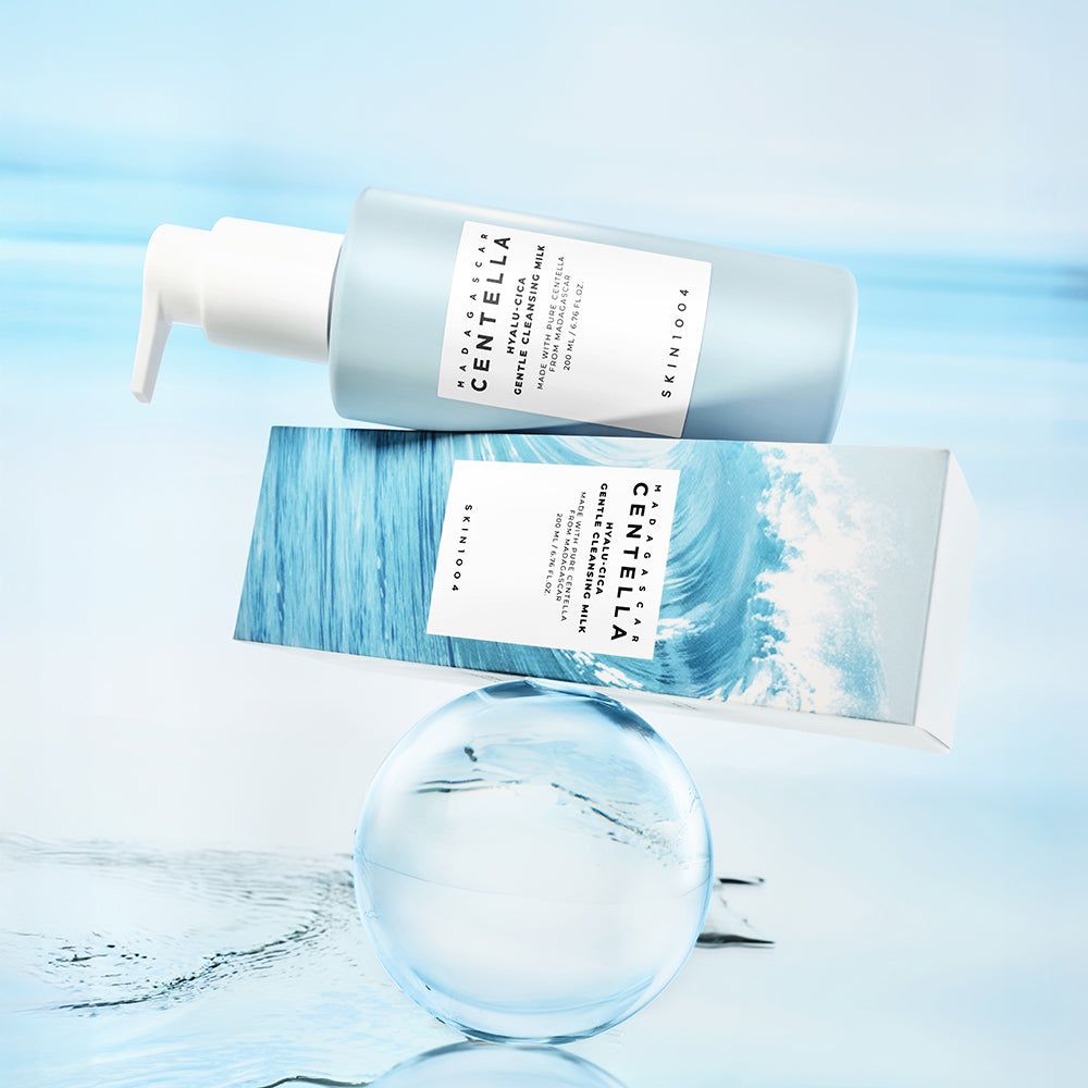 Hellblaues Fläschchen mit weißem Pumpkopf und Karton. Aufkleber mit Text: MADAGASCAR CENTELLA HYALU-CICA GENTLE CLEANSING MILK. SKIN1004.