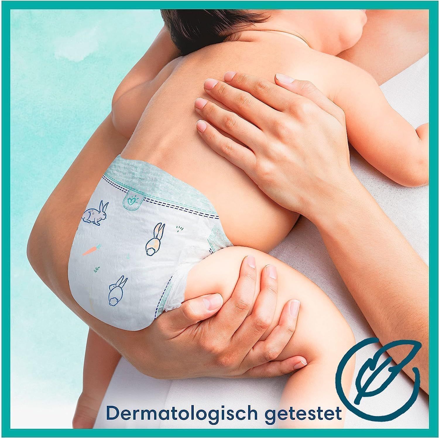 Baby mit Windel, im Arm gehalten. Windel mit Hasen-Motiv. Dermatologisch getestet.