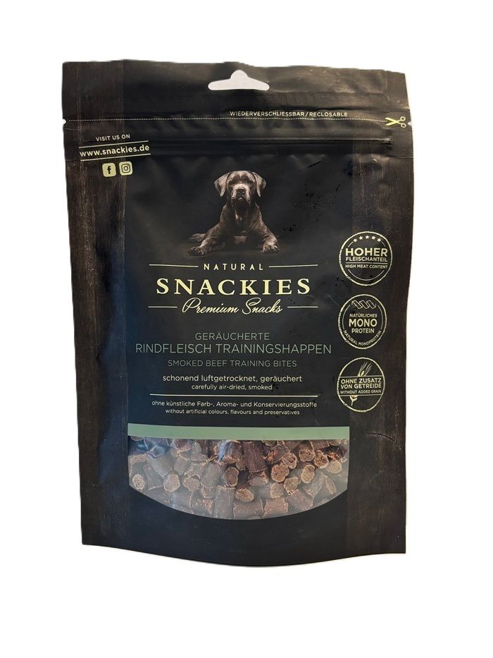 Verpackung mit Snackies Geräucherte Rindfleisch Trainingshappen. Schwarze Tüte mit Produktbild und Text. Sichtbare Fleischstücke.