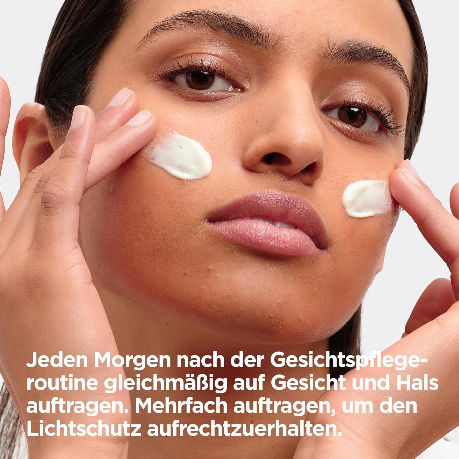 Eine Frau trägt Creme auf ihr Gesicht auf. Der Text beschreibt die Anwendung des Produkts nach der Gesichtsroutine.