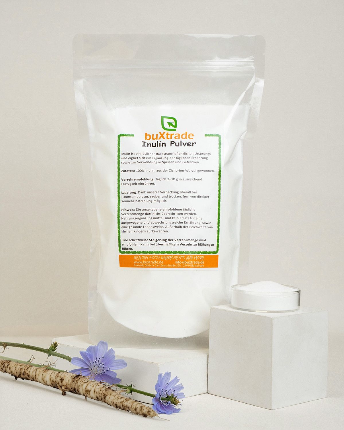 Buxtrade Inulin Pulver, Chicorée-Wurzeln, Blüten und ein Würfel mit Pulver.