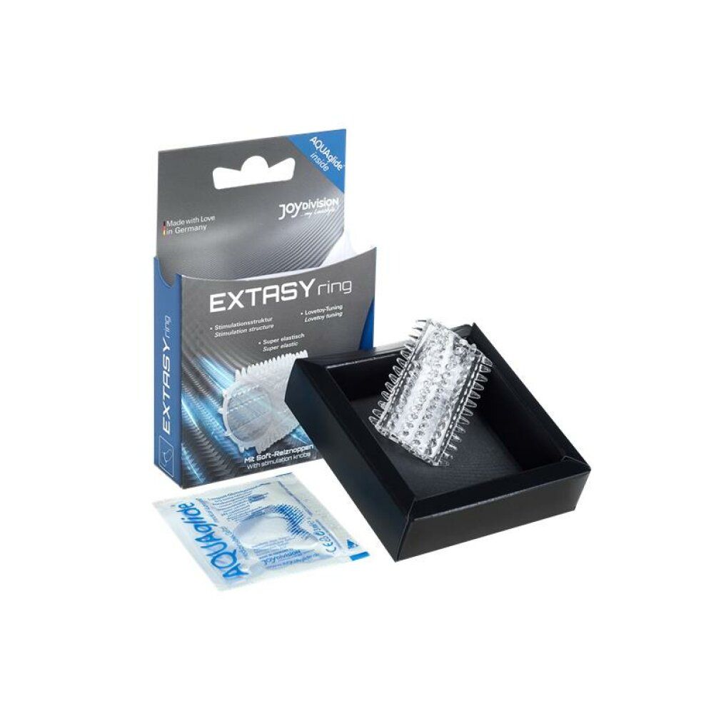 Transparentes EXTASYring in schwarzer Box, daneben Verpackung mit Gleitmittel. Produktname und Marke sichtbar.