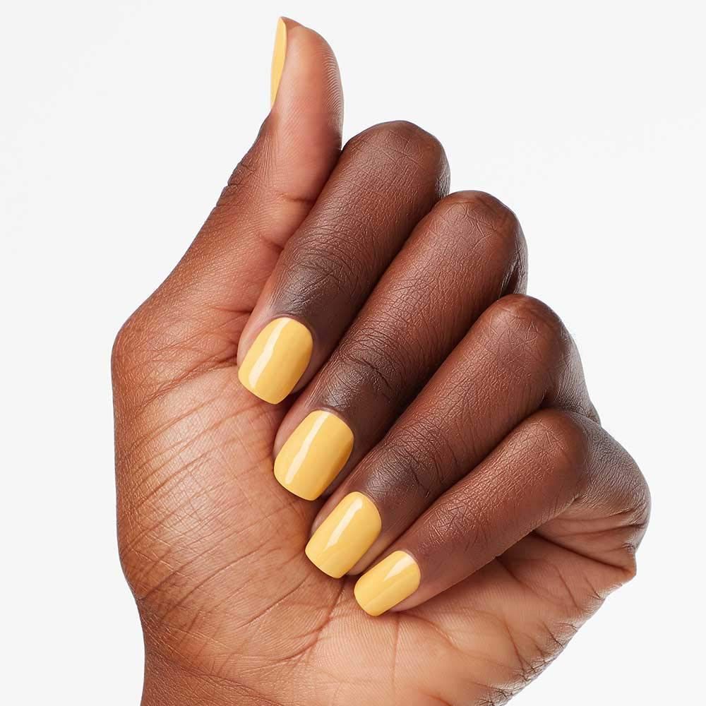 Hand mit gelbem Nagellack auf den Fingernägeln. Nahaufnahme.