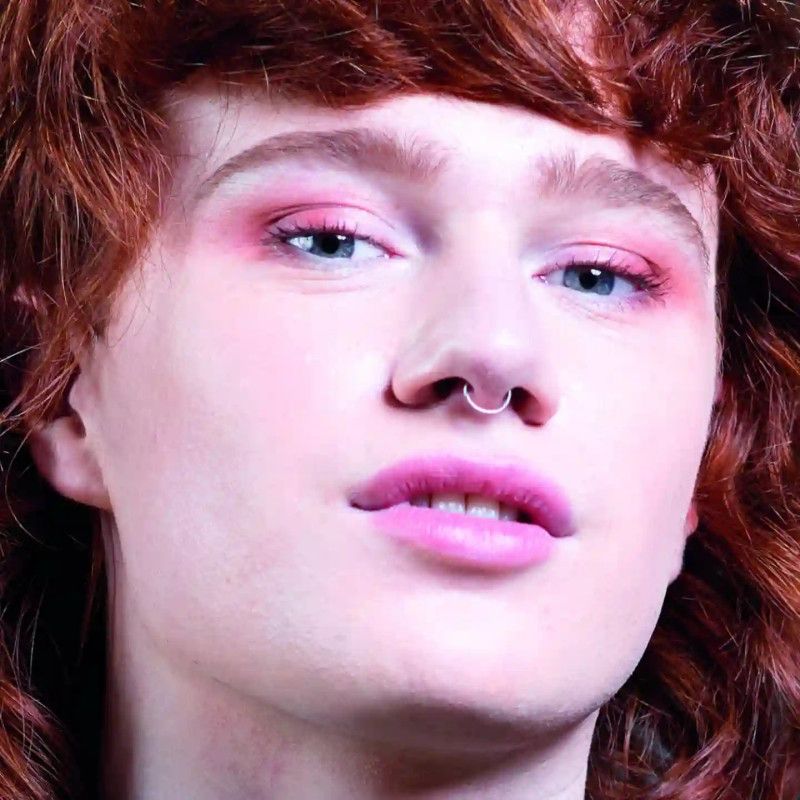 Nahaufnahme eines Gesichts mit rosa Lidschatten und Lippenstift.