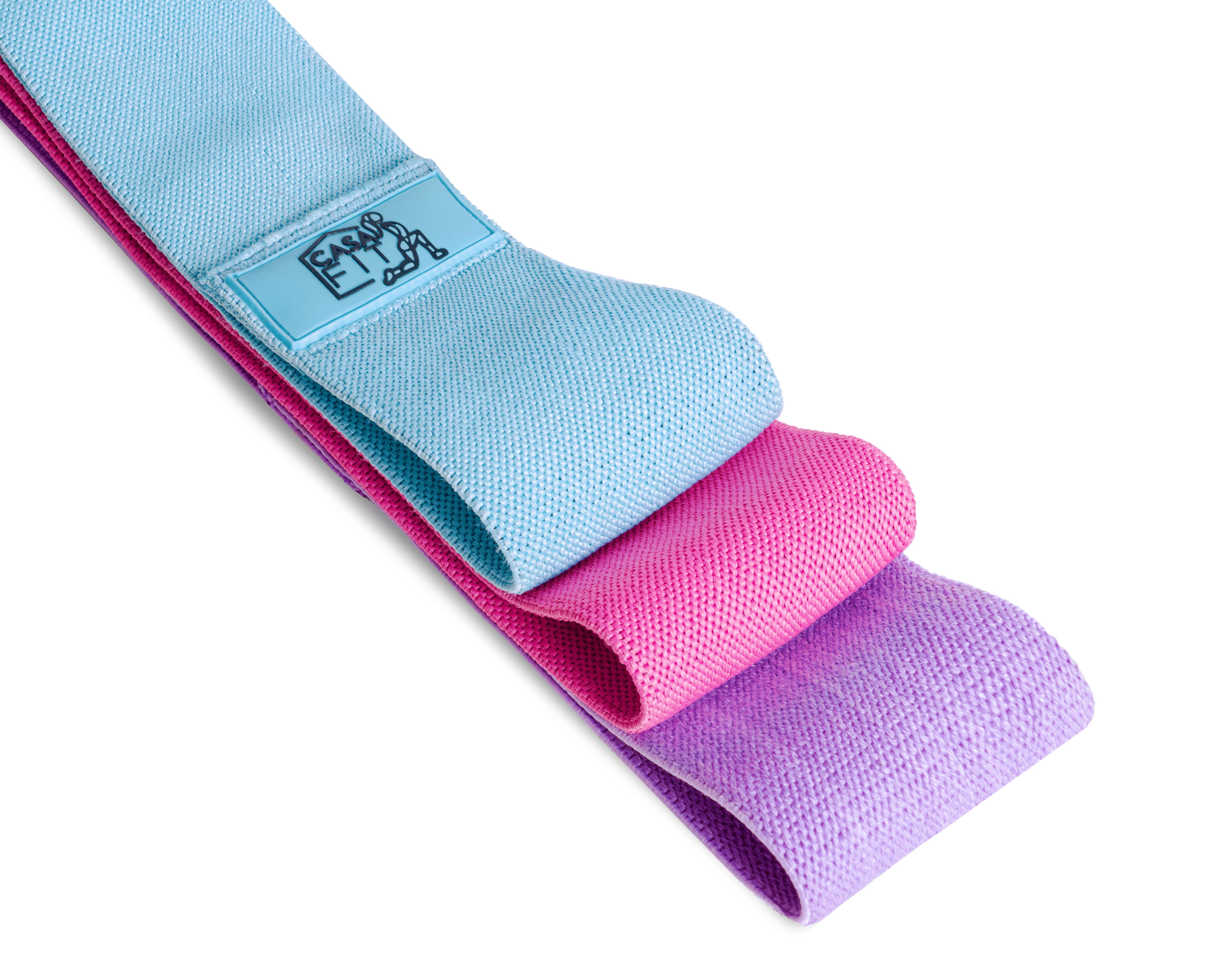 Drei Stoff-Widerstandsbänder in Pastelltönen: Hellblau, Rosa und Lila. Jedes Band hat ein kleines Logo.