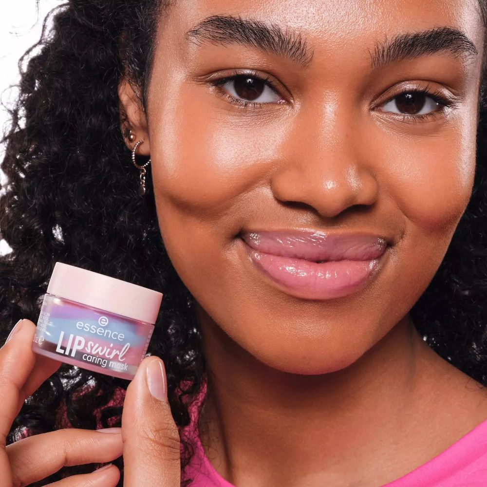 Eine Frau hält einen Tiegel mit Lippenmaske. Schriftzug: essence LIP swirl caring mask. Sie trägt rosa Kleidung.