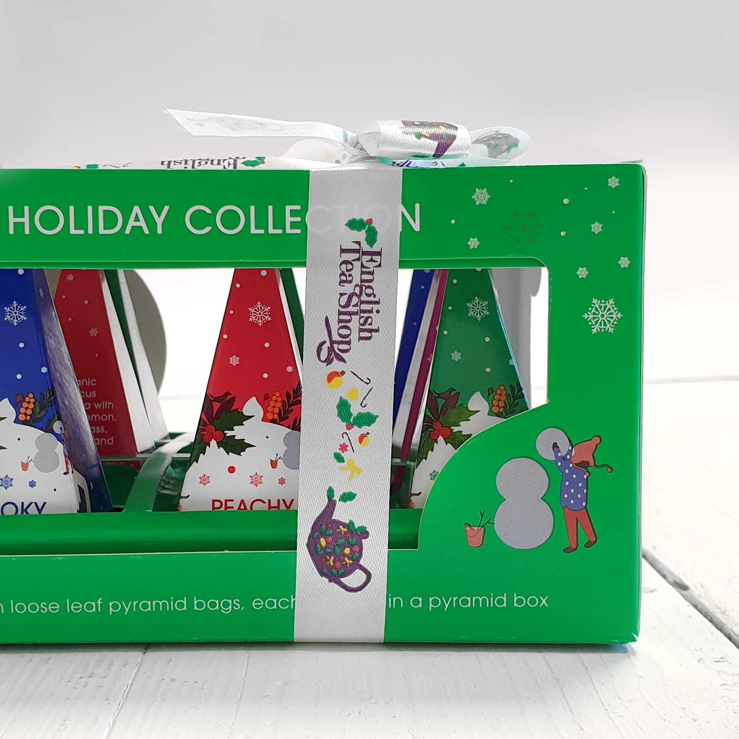 Grüne Box mit pyramidenförmigen Teebeuteln. Aufdruck: English Tea Shop, Holiday Collection. Mit Schleife.