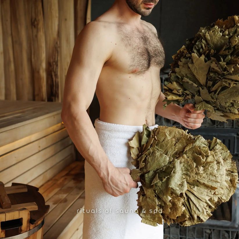 Mann hält zwei Bündel Birkenreisig. Er trägt ein Handtuch. Text: Rituals of sauna & spa.