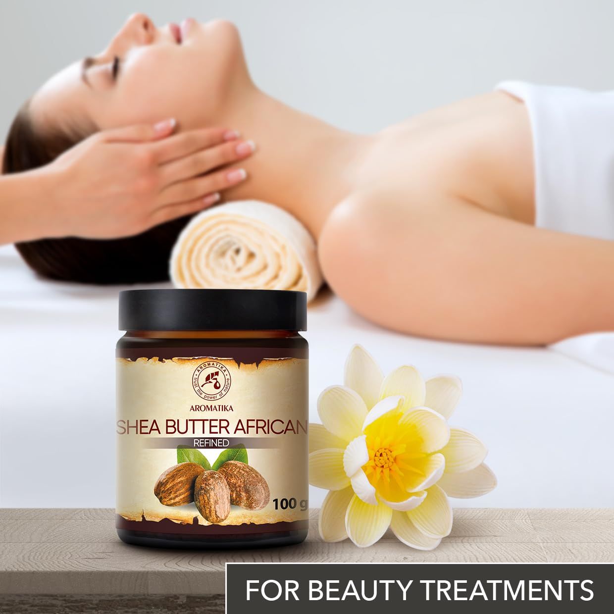 Glas mit AROMATIKA Sheabutter African, daneben eine Blüte und eine Frau, die eine Massage erhält.