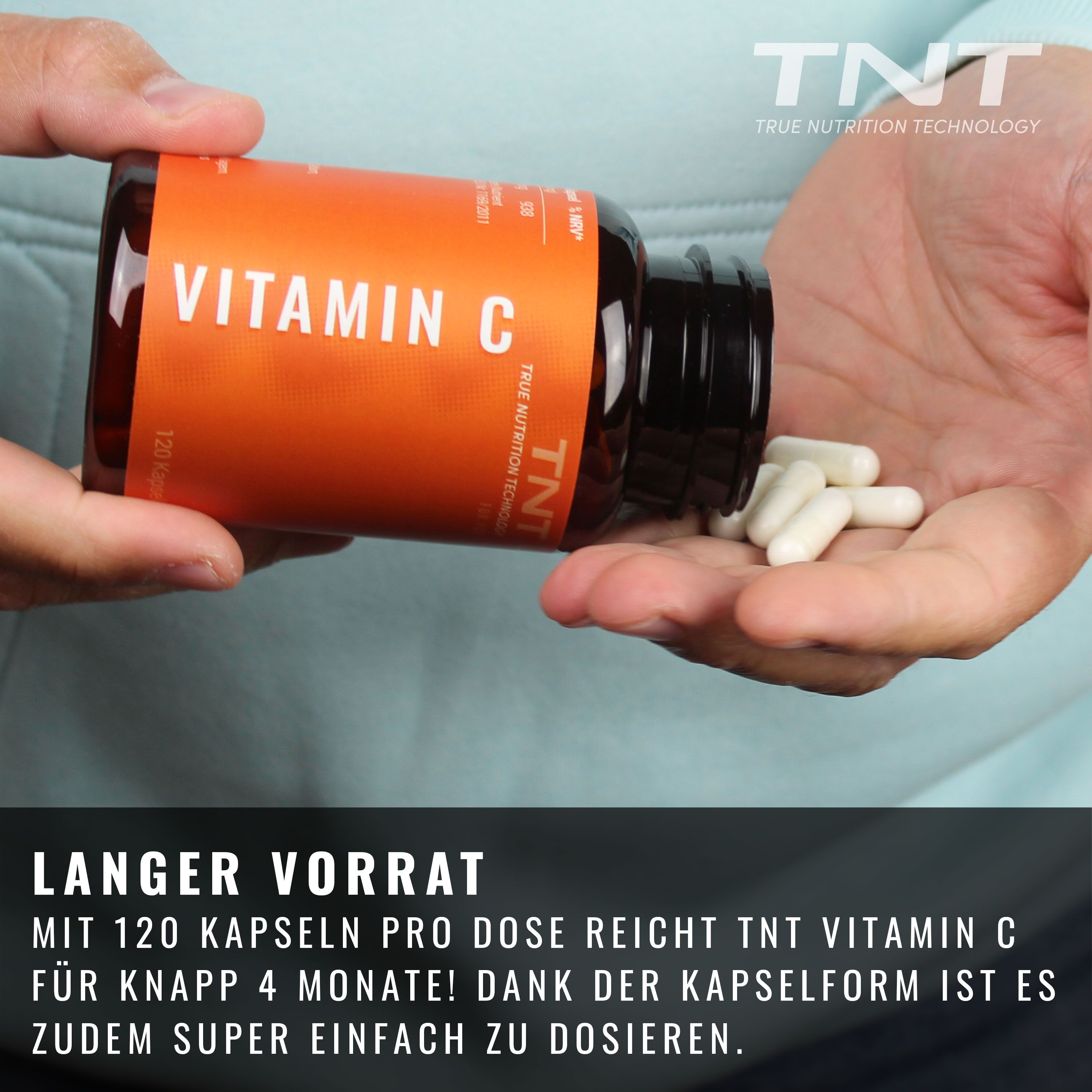 Hand hält braune Flasche mit Vitamin C Kapseln. Weiße Kapseln in der Handfläche.