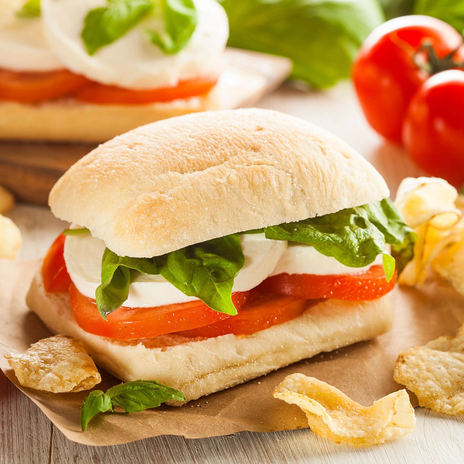 Ciabattini belegt mit Tomaten, Mozzarella und Basilikum.