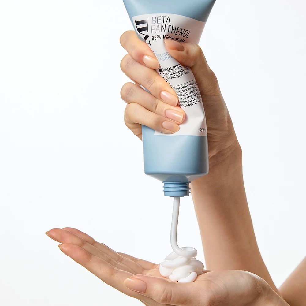 Creme wird aus einer blauen Tube in die Hand gedrückt. Produktname und Text auf der Tube.