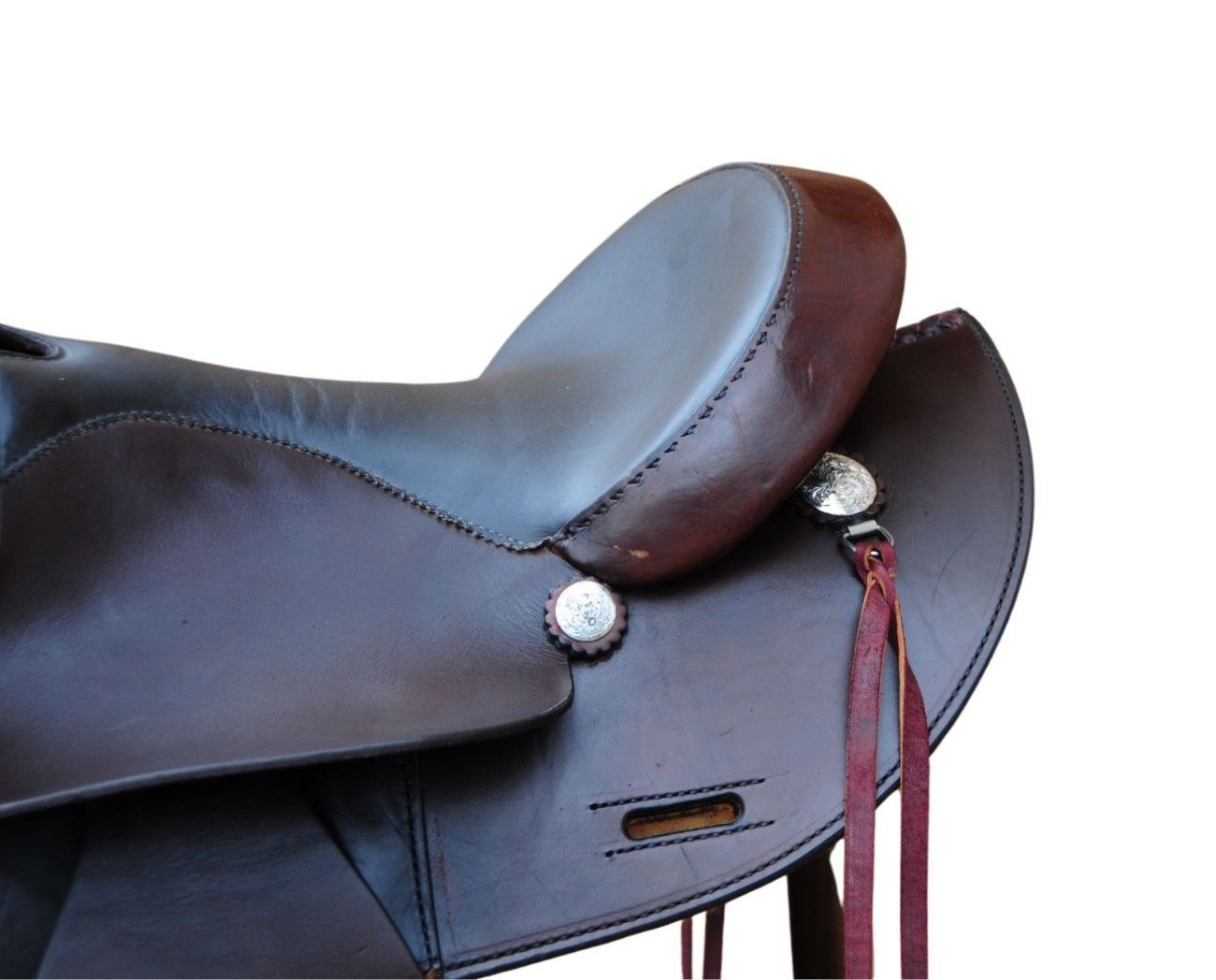 Brauner Westernsattel. Leder, Steigbügel, Ziernähte. Silberfarbene Verzierungen. Riemen mit Quasten.
