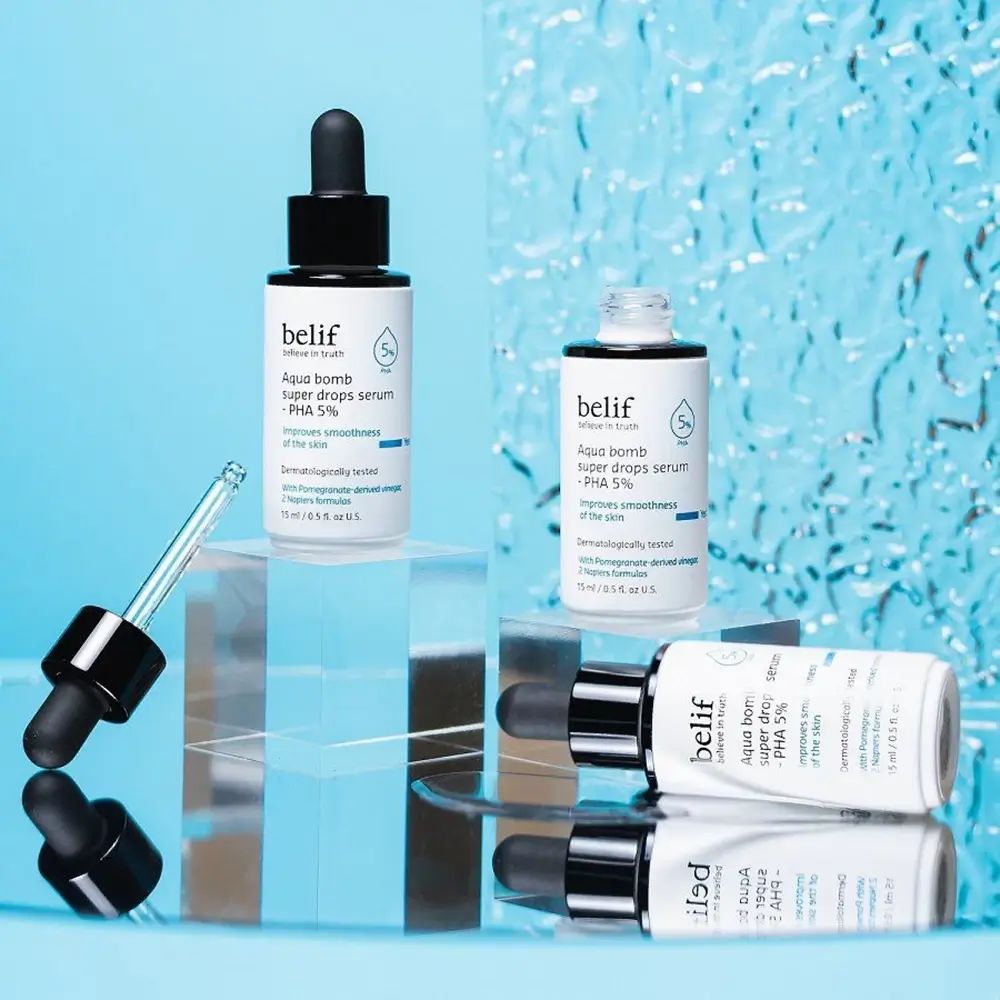 Mehrere Serumflaschen mit schwarzem Deckel und Pipette. Aufschrift: belif, Aqua bomb super drops serum - PHA 5%.