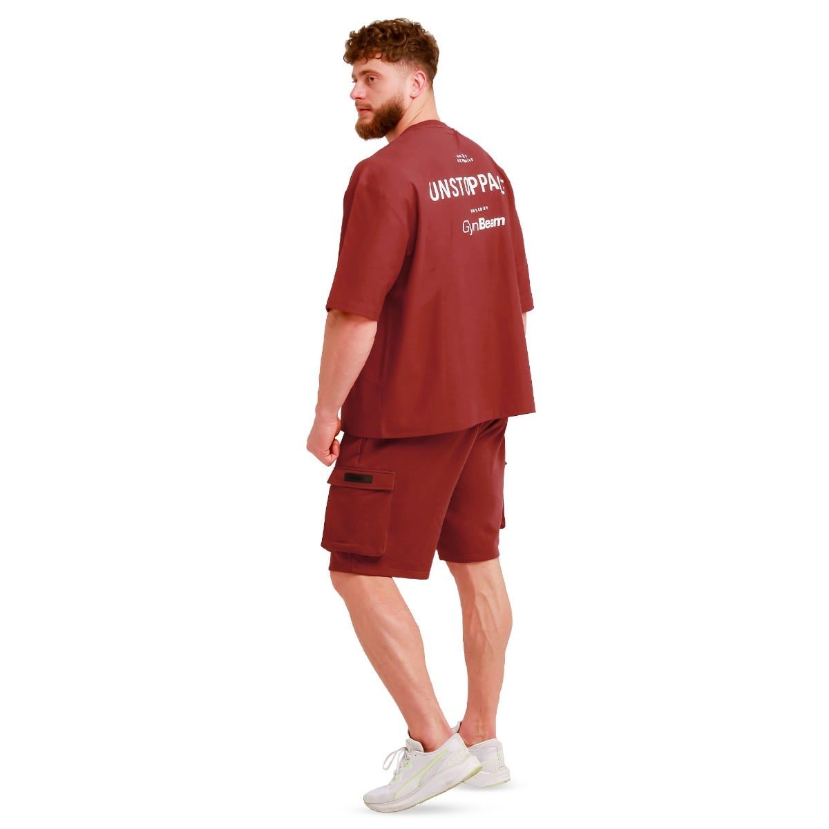 Mann in rotem Oversize T-Shirt und Shorts, von der Seite betrachtet, mit Aufdruck auf dem Rücken.