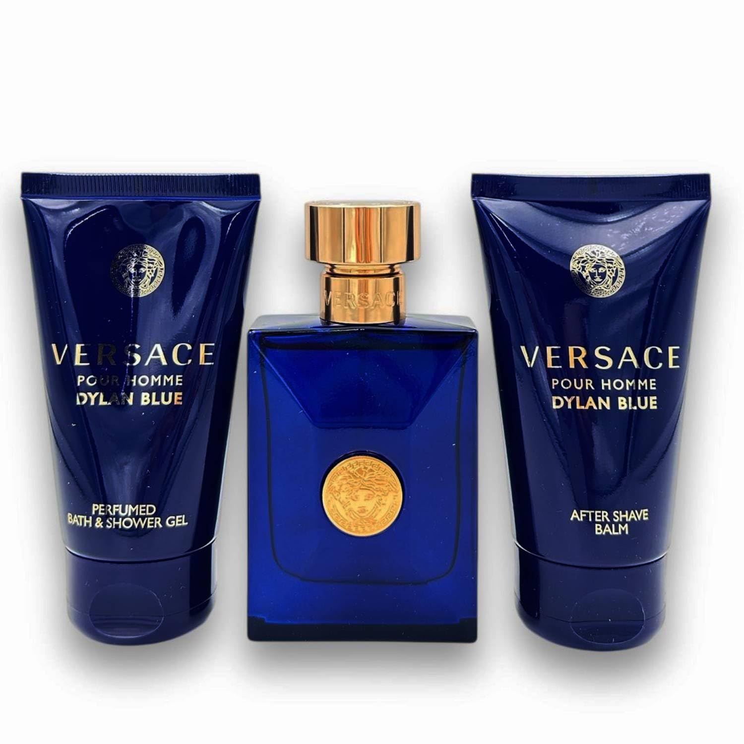 Drei blaue Tuben und eine blaue Flasche mit goldenen Verschlüssen. Auf den Tuben und der Flasche ist das Versace-Logo zu sehen.