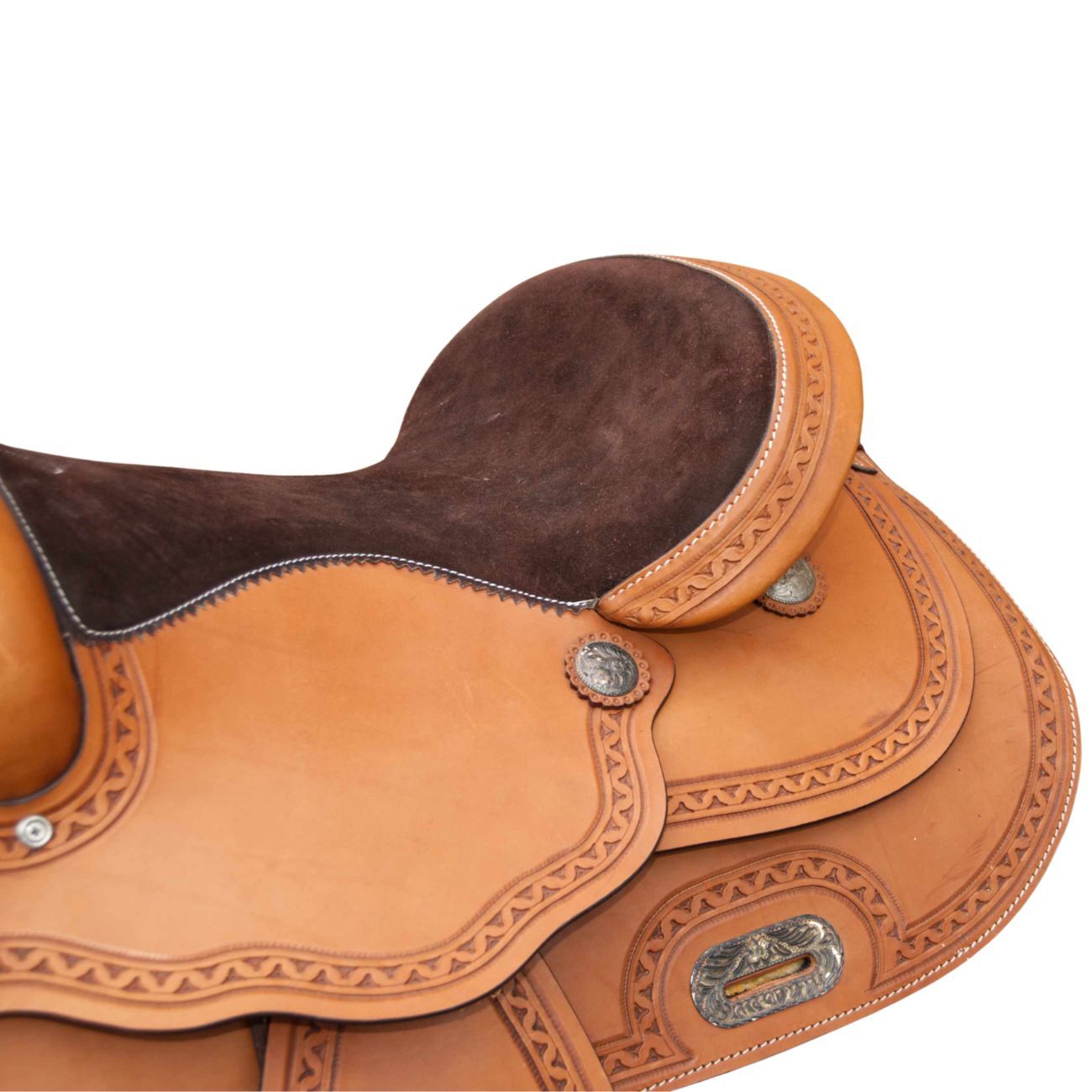 Nahaufnahme eines braunen Westernsattels. Geprägte Muster, silberne Beschläge, braune Sitzfläche, detaillierte Lederarbeit.