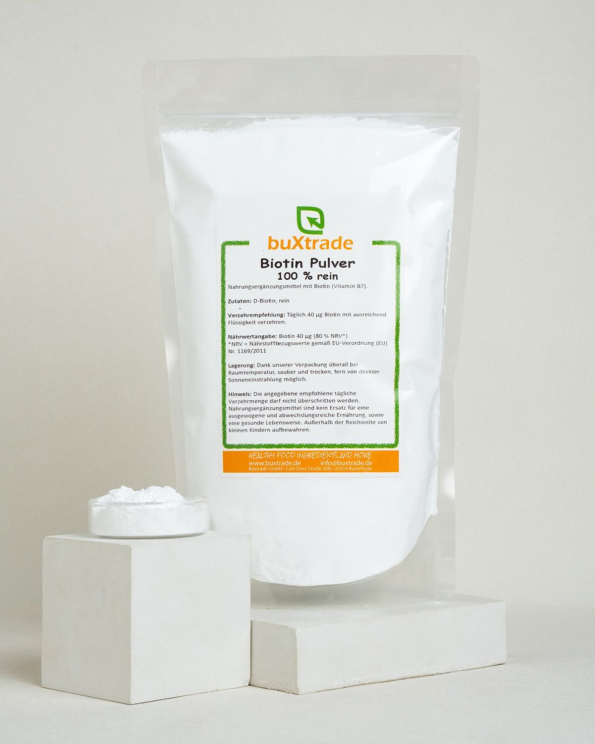 Ein Beutel buxtrade Biotin Pulver und eine kleine Schale mit Pulver.