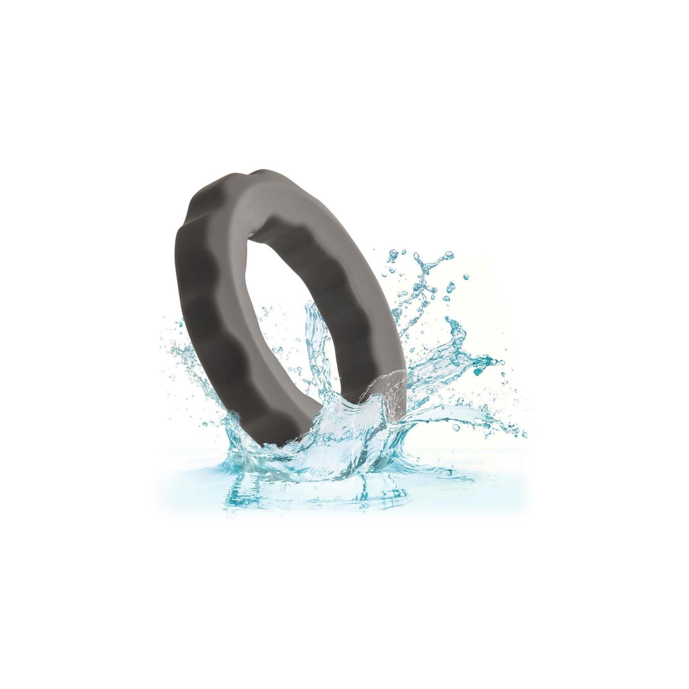 Grauer Silikon-Erektionsring spritzt in Wasser.