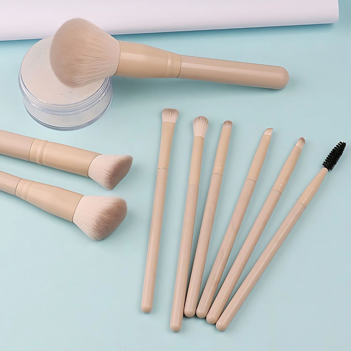 Ein Set aus acht Make-up-Pinseln mit hellbeigen Griffen und hellen Borsten. Ein Pinsel ist ein großer Puderpinsel, die anderen sind kleinere Augen-Make-up-Pinsel und ein Mascara-Bürstchen.