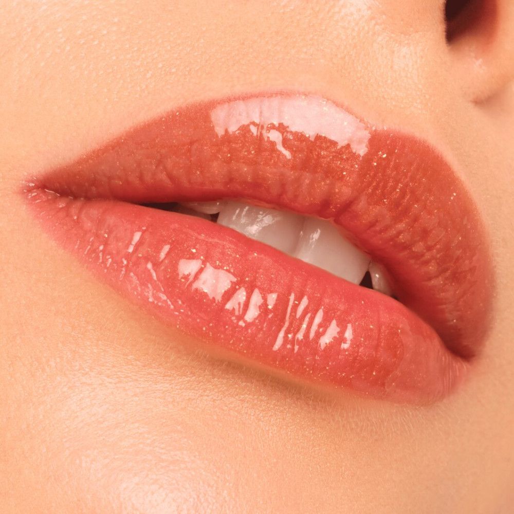 Nahaufnahme von Lippen mit aufgetragenem Lipgloss. Glänzendes Finish. Lippen in einem bronzefarbenen Ton.