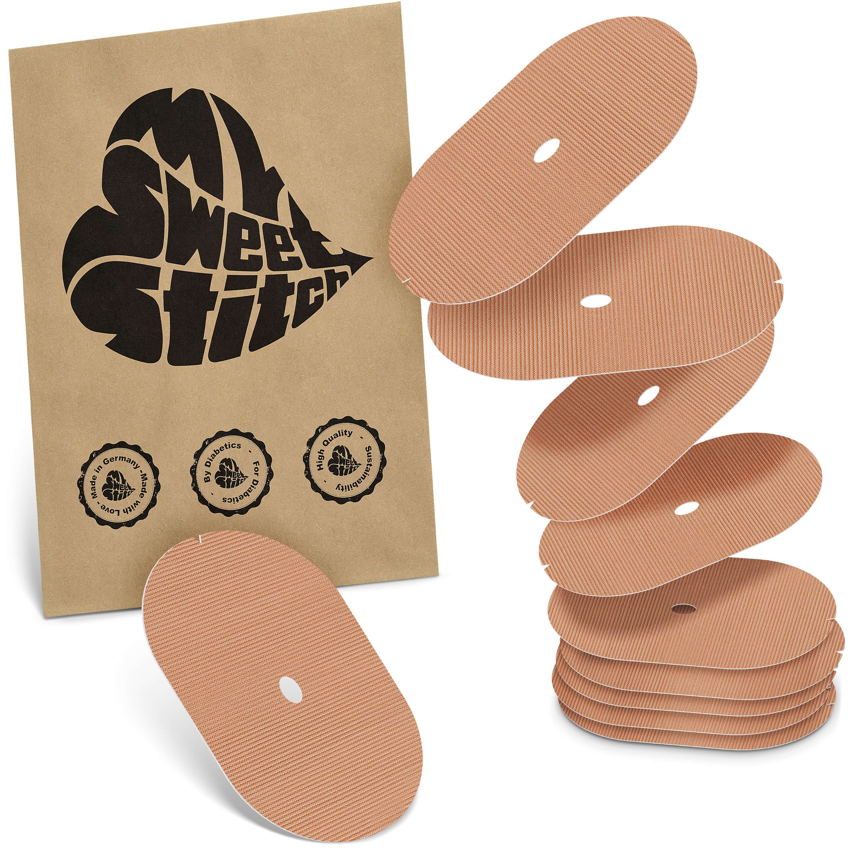 Beige ovale Pflaster mit Loch, neben brauner Verpackung mit Logo und Qualitätssiegeln. Mehrere Pflaster gestapelt.