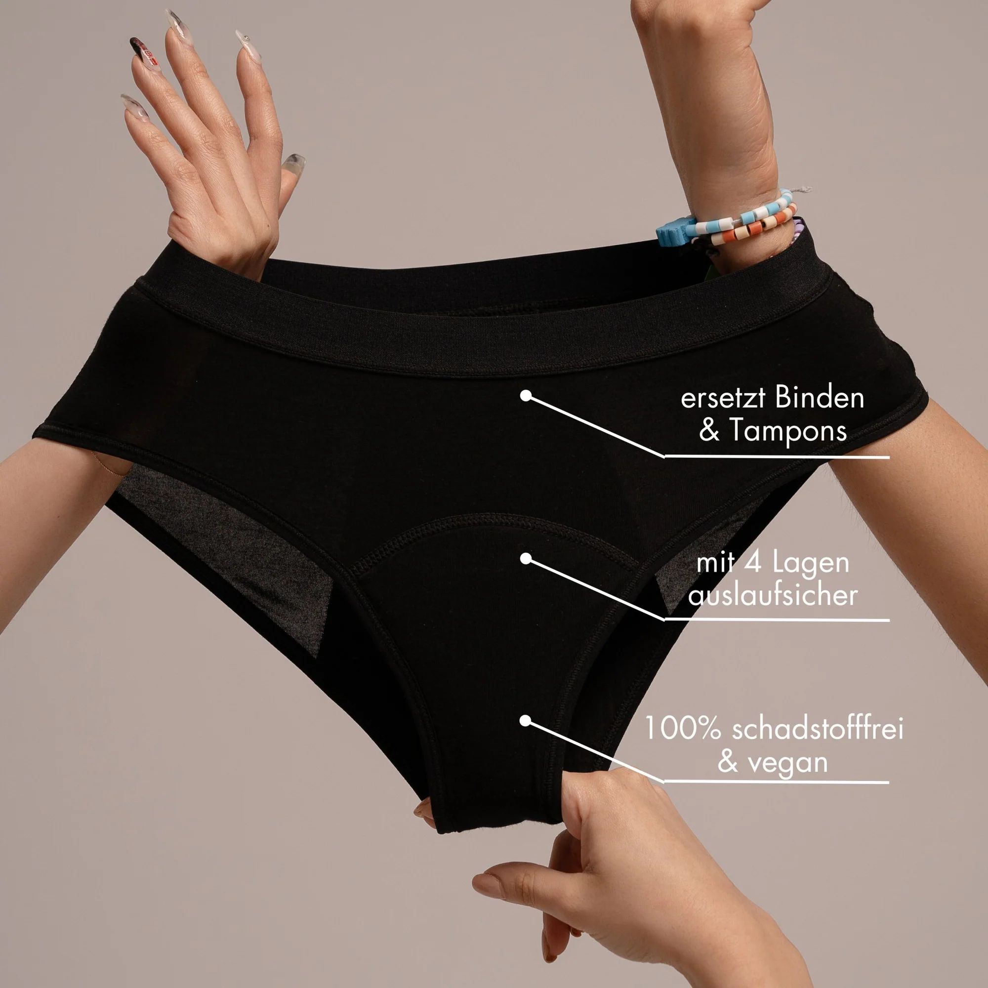 Schwarzer Slip, gehalten von zwei Händen. Text: Ersetzt Binden & Tampons, mit 4 Lagen auslaufsicher, 100% schadstofffrei & vegan.