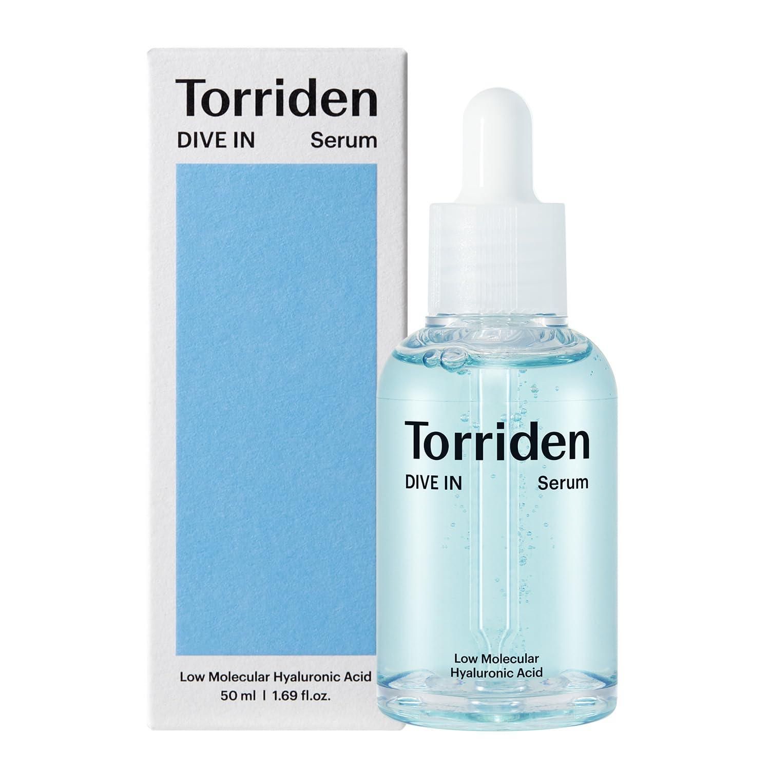 Serumflasche und Verpackung. Aufschrift: Torriden DIVE IN Serum. Blaue Flüssigkeit in einer Glasflasche mit Pipette. Weiße Verpackung.