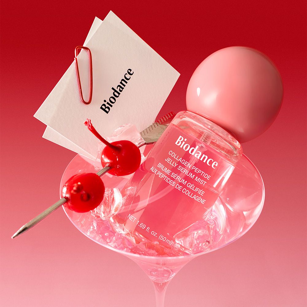 Biodance Collagen Peptide Jelly Serum Mist Flasche mit Kirschen und Eiswürfeln in einem Glas.