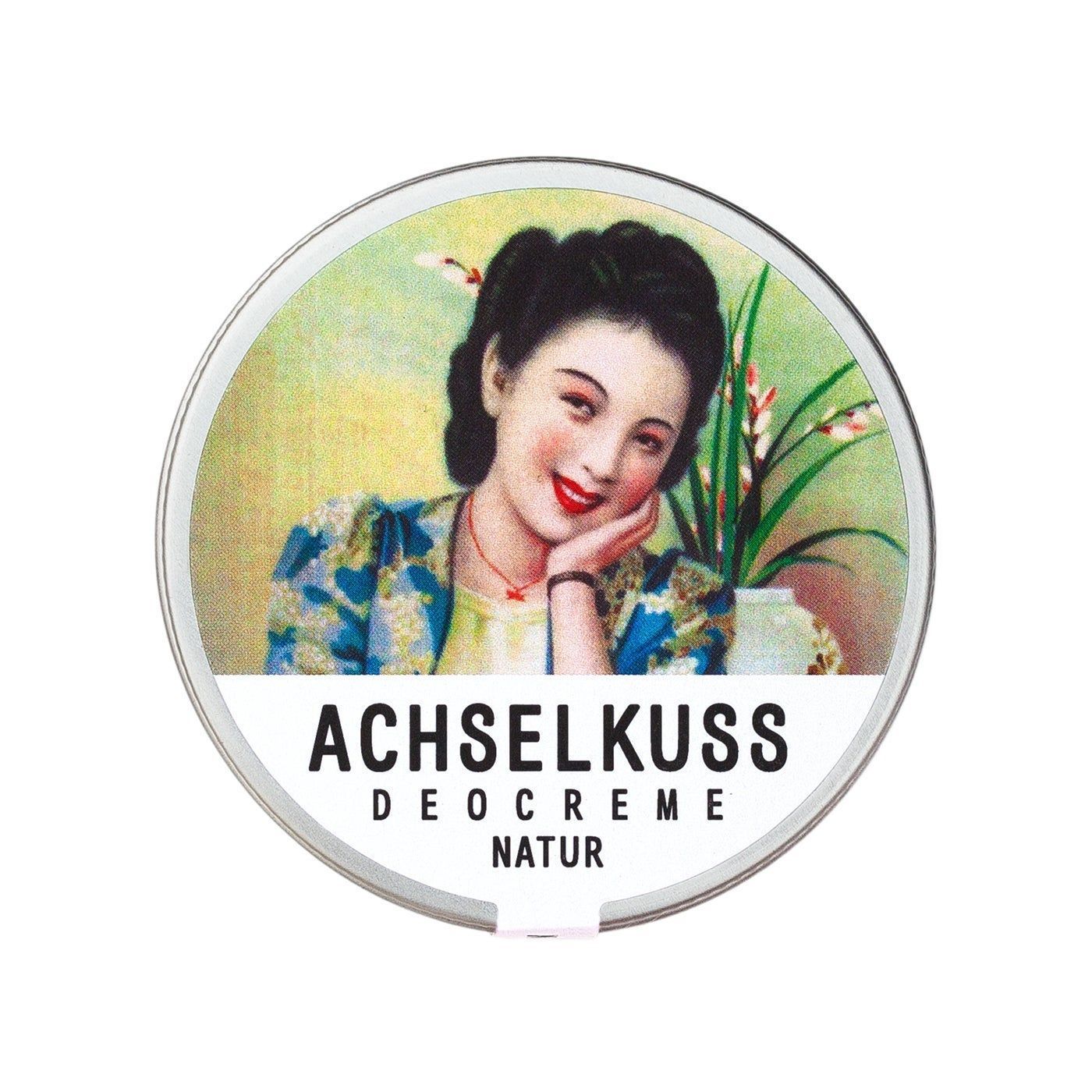Runde Dose mit Deckel. Auf dem Deckel ein Bild einer Frau. Darunter steht "ACHSELKUSS DEOCREME NATUR".