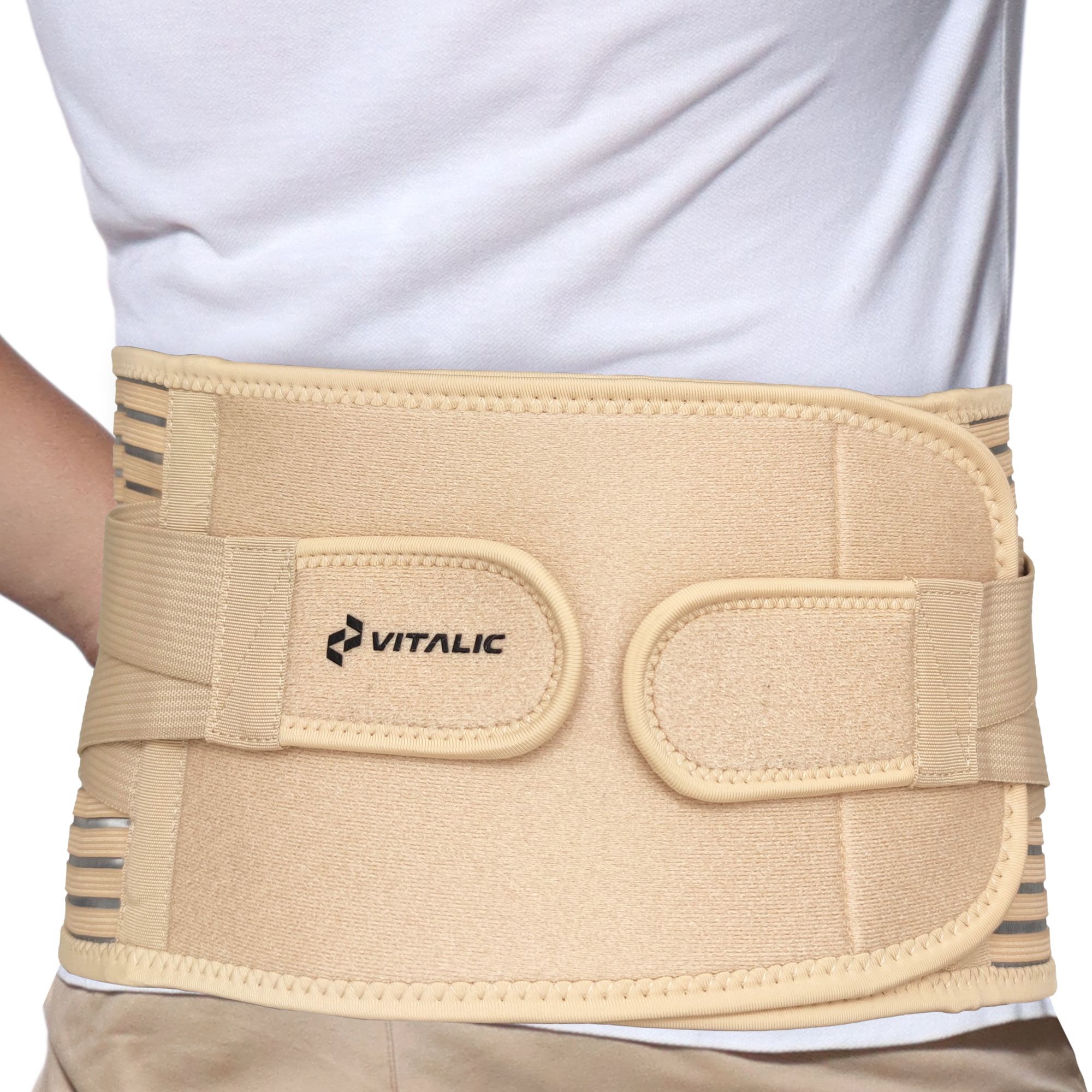 Beige Rückenbandage, getragen von einer Person. Mit Klettverschlüssen und dem Logo.