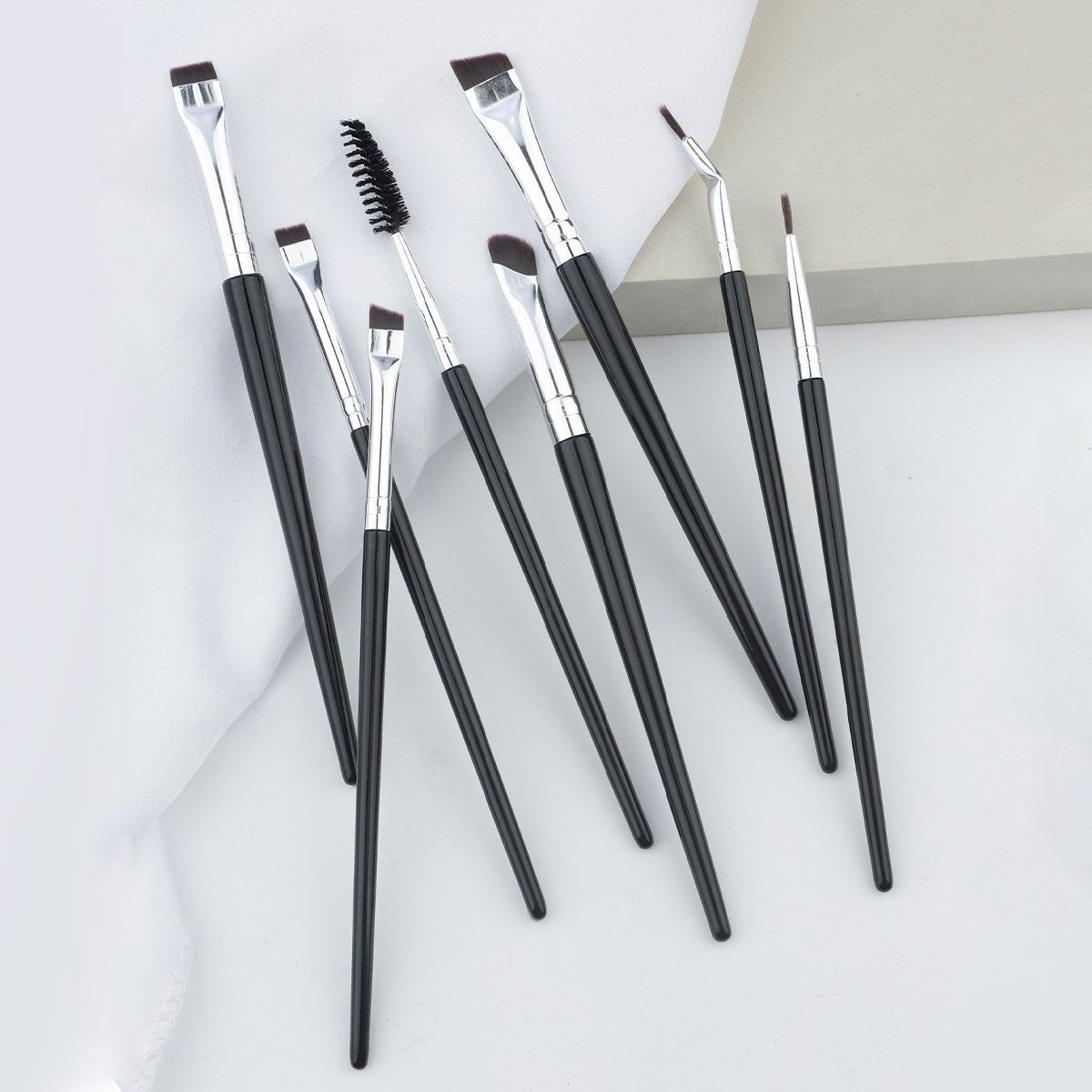 Set mit acht schwarzen Make-up-Pinsel mit silbernen Applikatoren.