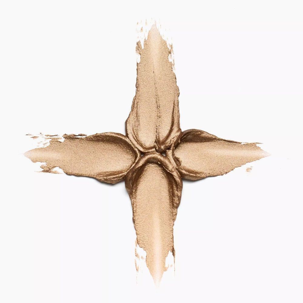 Goldfarbener Creme-Lidschatten-Abstrich in Kreuzform. Auf weißem Hintergrund. Textur sichtbar.