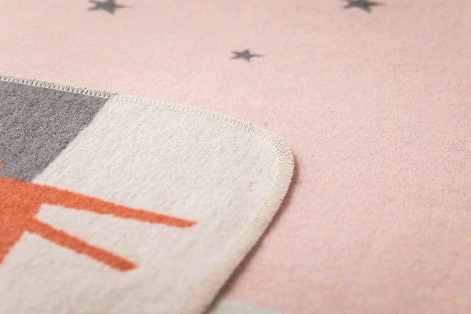 Graue Decke mit orangefarbenem Fuchs und rosa Sternen.